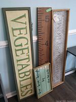 Group shot of all four wall decor signs leaning against wall