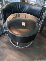 Front view of black faux leather swivel accent chair on chrome base
