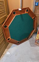 Full view of octagonal poker table top showing felt surface and cup holders