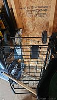 Cart folded, showing wire basket and large black wheels