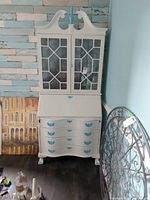 Full view of secretary desk cabinet showing glass doors, drop-front desk, drawers