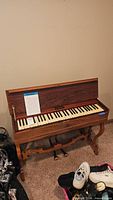 Front view of spinet piano showing full keyboard and carved legs