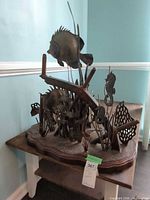 Front view of metal sea-life sculpture on wood base
