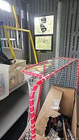 Front and side view of red metal hockey goal with net