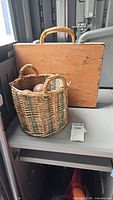 Wooden horseshoe case and wicker basket with handle on table