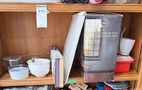 Shelf view showing clear glass bowls, yin-yang ceramic bowl, white ramekin, boxed items, coffee maker and red container