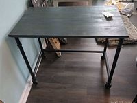 Full view of table showing wood top, metal legs, casters