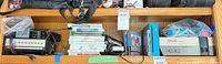 Shelf view with scanner radio left, stack of Wii cases centre, NES cartridges and consoles right