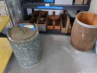 Galvanized can, wooden trays on shelf, wooden barrel visible