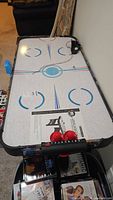 Top view of air hockey table with pushers and manual on surface