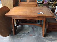 Front view of wooden dining table with butterfly leaf closed