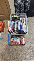 Two-tier bin holding stack of DVDs above row of VHS tapes