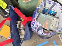 Two reusable bags filled with jewel-case CDs; FireHouse album visible on top