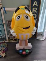 Front view of M&M's Yellow character dispenser on base