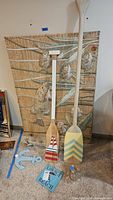 Overall lot showing woven fish panel, two oars, anchor hook, sign and bottles