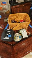 Overview showing wicker basket, stack of black square icon coasters, round Disney coaster, bar tools inside basket