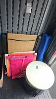 Stacked items showing wicker panel, folded chairs, table side view