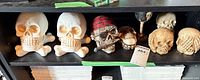 Shelf view of six skull items