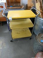 Full view of yellow three-shelf rolling cart