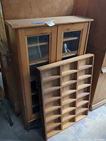 Front view of cabinet with glass doors and separate cubby organizer leaning against it