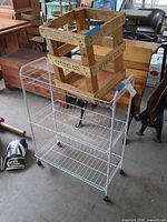 White wire rolling cart with wood crate placed on top