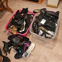 Two plastic bins filled with assorted women’s shoes on carpet