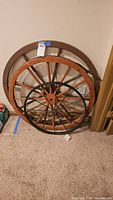 Three wagon wheels leaning against wall