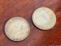 Both coins obverse sides visible on wood surface