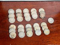 All 31 worn Canadian silver quarters laid out on wood surface