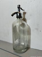Front view of clear etched glass seltzer bottle with chrome siphon top