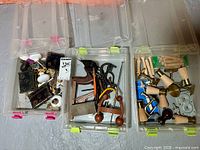 Three clear plastic bins filled with assorted hardware and hand tools