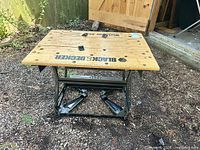 Full view of folded Black & Decker Workmate workbench showing wooden top and steel frame