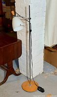 Full view of chrome floor lamp with white shade and wood base