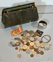 Purse, tin, coins, bracelets, stamps overall view