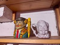 Both figural mugs on shelf