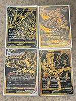 All four black and gold Pokémon cards laid out