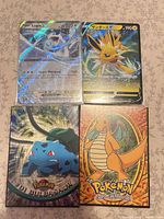 Group shot of four Pokémon cards: Lugia EX, Jolteon, Bulbasaur, Charizard