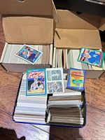 Boxes and tin filled with baseball cards, visible Score Dale Murphy and Royals, Cubs cards