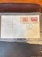 Full view of envelope in sleeve showing both stamps and postmark