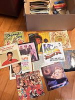 Open box of 7-inch singles with several sleeves displayed