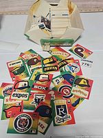 Spread of 1983 Fleer MLB team logo stickers arranged on surface