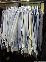 Rack of blue and white long sleeve dress shirts on hangers