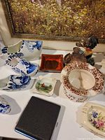 Overall lot showing ashtrays, Delft clogs, cigarette case and figurine