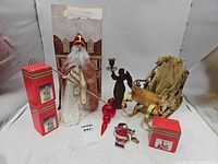 Overall lot showing St. Nick figurine, sleigh, candleholder, ornament boxes, and loose ornaments