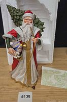 Full figurine with partial styrofoam packaging, card and lot tag visible