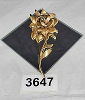 Front view of gold-tone rose brooch showing full shape and finish