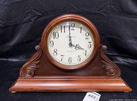 Front view of wood mantel clock showing dial and case