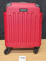 Front exterior of red Kenneth Cole Reaction hardside carry-on suitcase with wheels