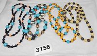 all four multi-colored bead necklaces laid flat on tray