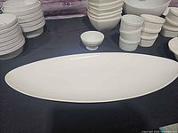 Wide view showing oval platter, multiple bowl stacks and ramekins